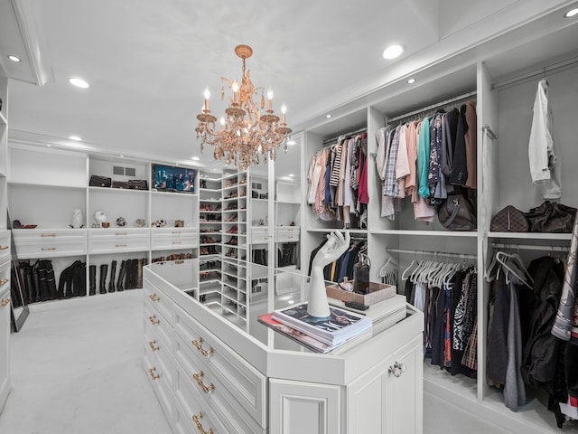 spacious closet with light colored carpet and a chandelier