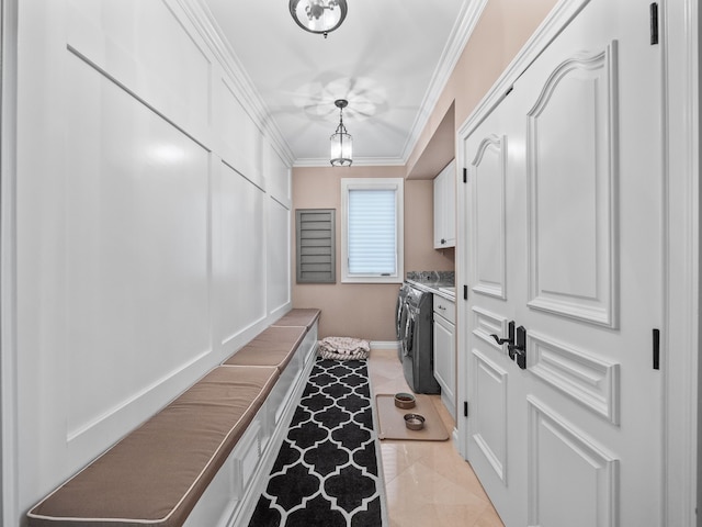 laundry area with washing machine and dryer, light tile patterned floors, cabinets, and ornamental molding