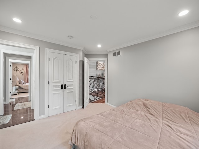 carpeted bedroom with ornamental molding and a closet