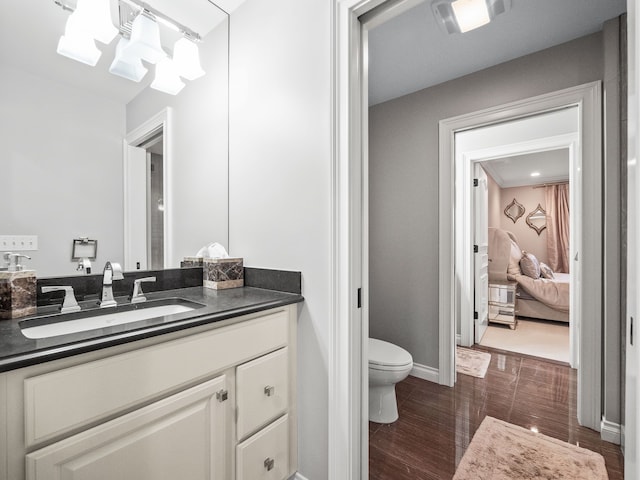 bathroom with vanity, hardwood / wood-style flooring, toilet, and an inviting chandelier