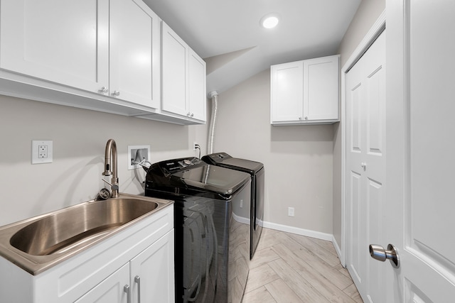 laundry room with cabinets, washing machine and dryer, light parquet floors, and sink