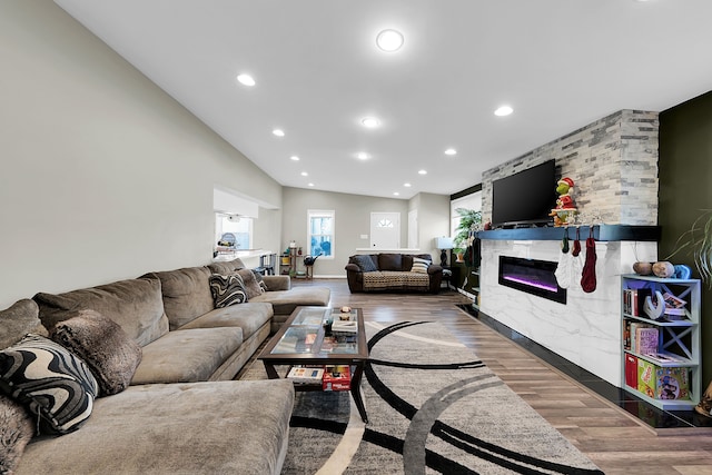 living room with a fireplace, wood-type flooring, and lofted ceiling