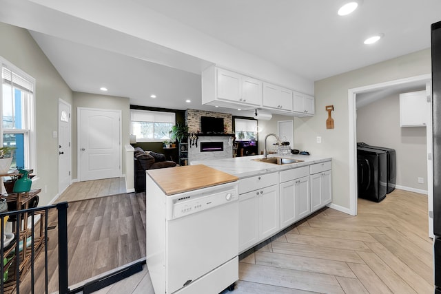 kitchen featuring dishwasher, independent washer and dryer, white cabinetry, and sink