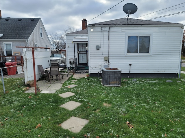 back of house featuring a lawn, central AC, and a patio area