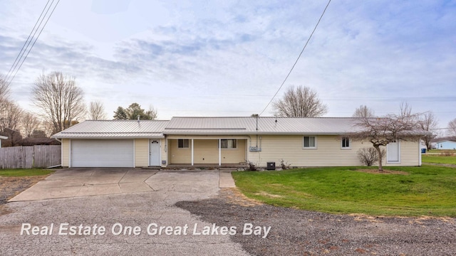 ranch-style home with a garage, central AC unit, and a front lawn