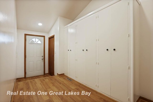 interior space with vaulted ceiling and light hardwood / wood-style floors