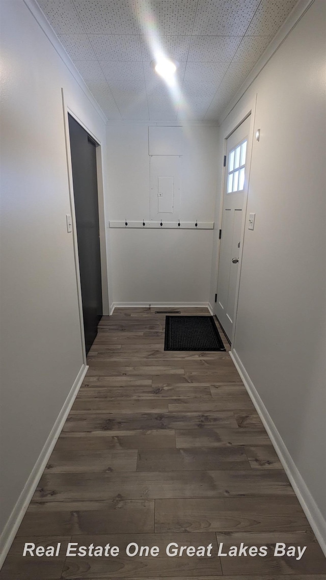 corridor with ornamental molding and dark hardwood / wood-style flooring