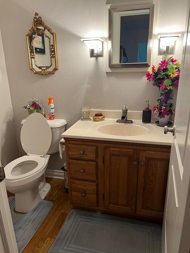 bathroom with hardwood / wood-style floors, vanity, and toilet