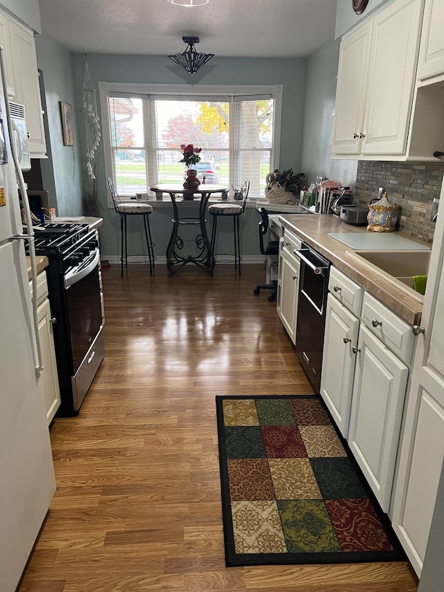 kitchen with white cabinetry, dishwasher, and a healthy amount of sunlight