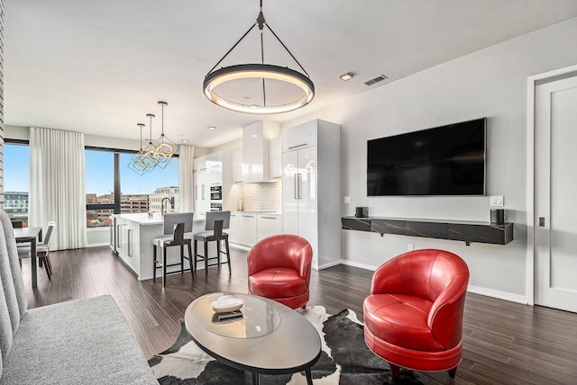 living room with dark hardwood / wood-style floors and an inviting chandelier