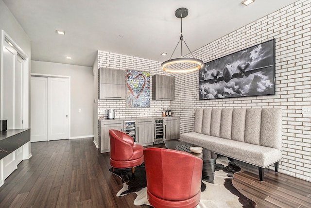 living room featuring hardwood / wood-style floors, wine cooler, and brick wall