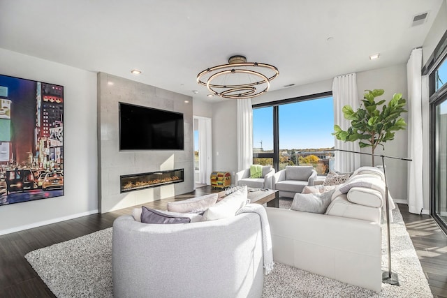 living room with a fireplace, dark wood-type flooring, and a wealth of natural light