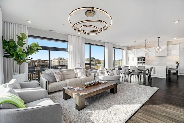 living room featuring dark hardwood / wood-style flooring and an inviting chandelier