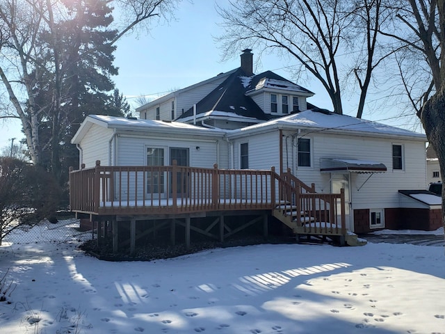 snow covered house featuring a deck