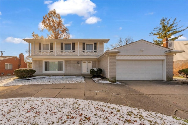 22679 Bell Brook St, Southfield, MI 48034 - view of front of house featuring an attached garage, brick siding, driveway, and covered porch