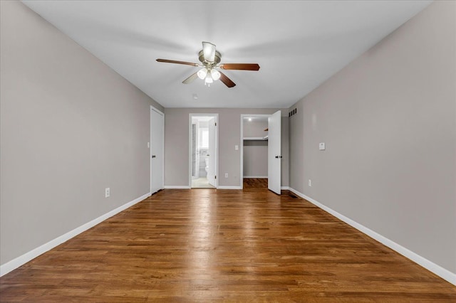 spare room with ceiling fan and dark wood-type flooring