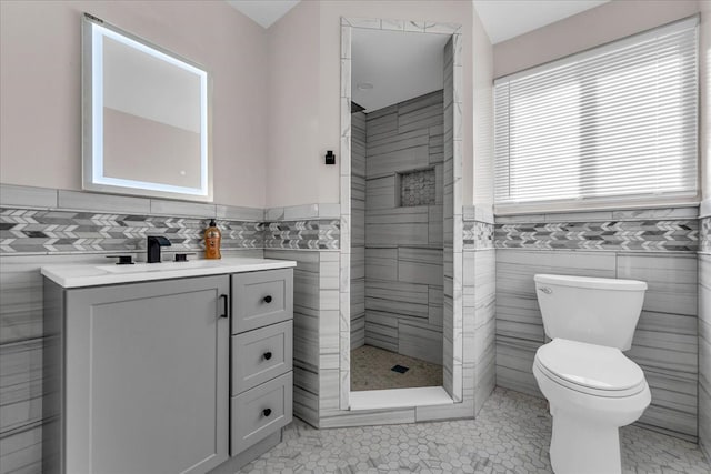 22679 Bell Brook St, Southfield, MI 48034 - bathroom with tile walls, toilet, a shower stall, vanity, and a wainscoted wall