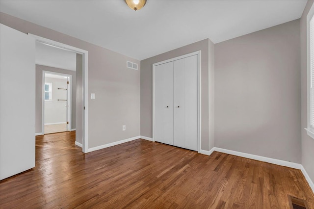 unfurnished bedroom featuring a closet and hardwood / wood-style floors