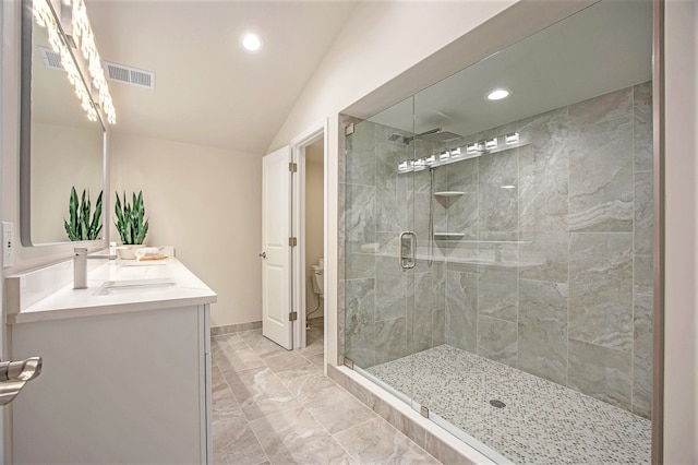 bathroom with vanity, toilet, lofted ceiling, and walk in shower