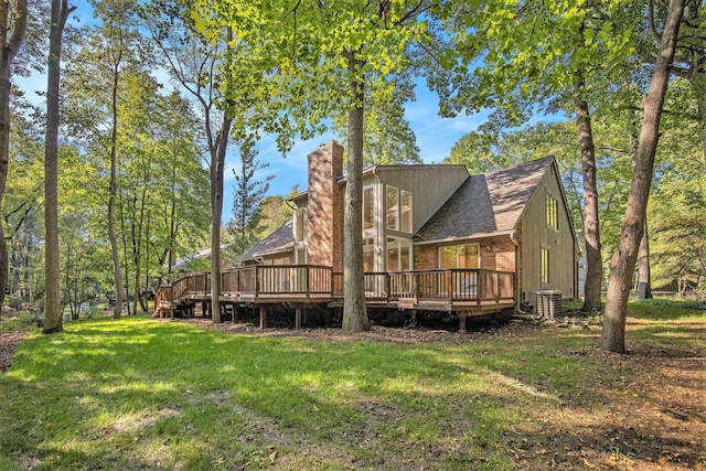 rear view of property featuring a wooden deck, a yard, and cooling unit