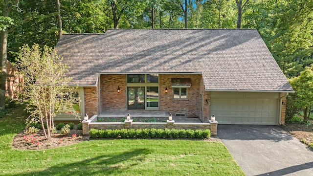 view of front facade with covered porch, a front yard, and a garage