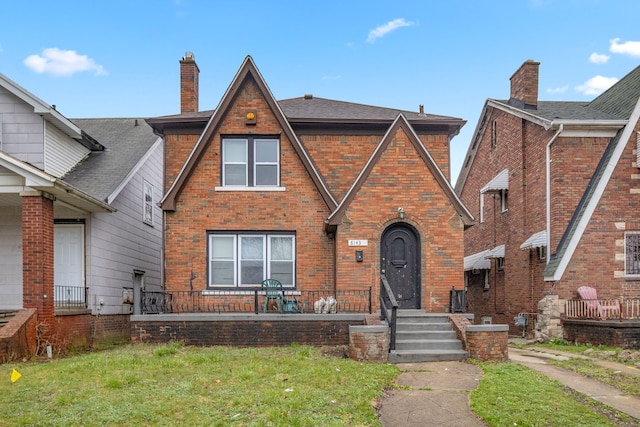 tudor home with a front lawn