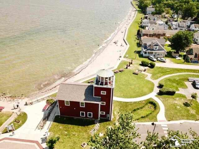 birds eye view of property featuring a water view and a beach view