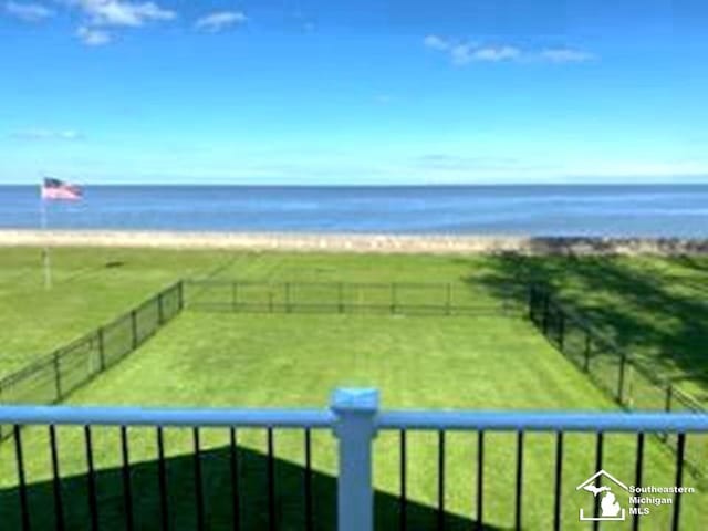 view of community featuring fence, an enclosed area, and a water view