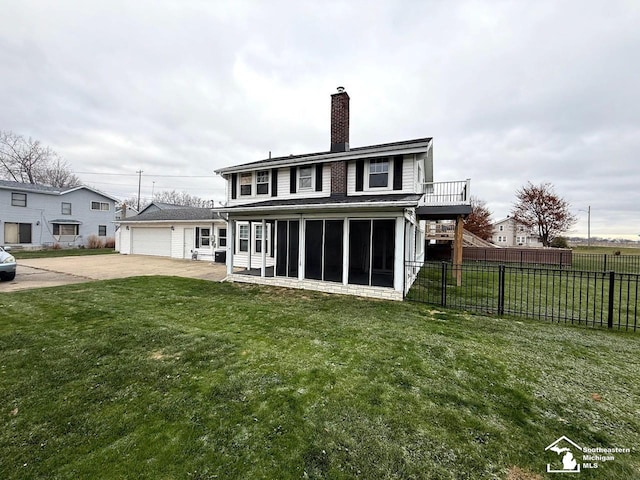 back of house featuring a garage, a lawn, and a sunroom