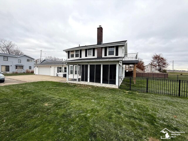 back of house with a chimney, a yard, fence, a sunroom, and concrete driveway