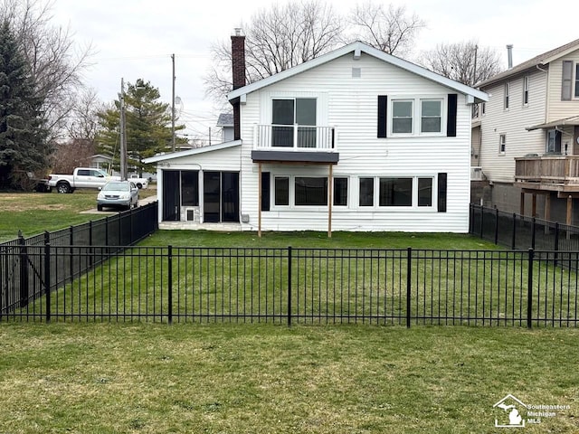rear view of property with a lawn, a fenced backyard, and a sunroom