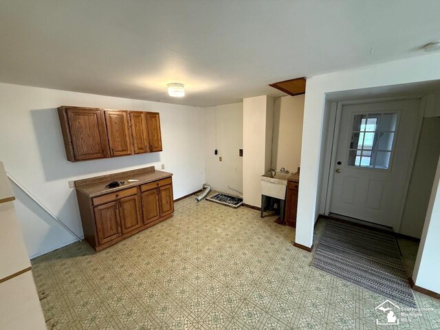 clothes washing area with light floors and baseboards