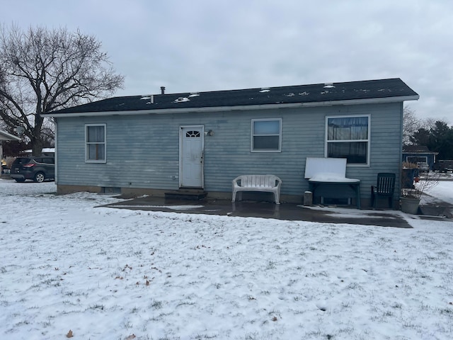 view of snow covered back of property