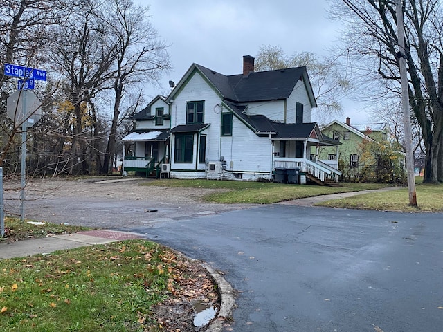 view of home's exterior with a lawn and a porch