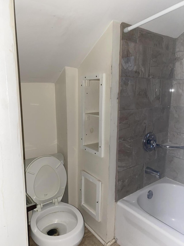 bathroom with toilet, tiled shower / bath, and vaulted ceiling