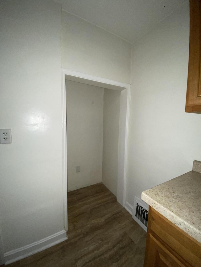 laundry area featuring dark wood-type flooring