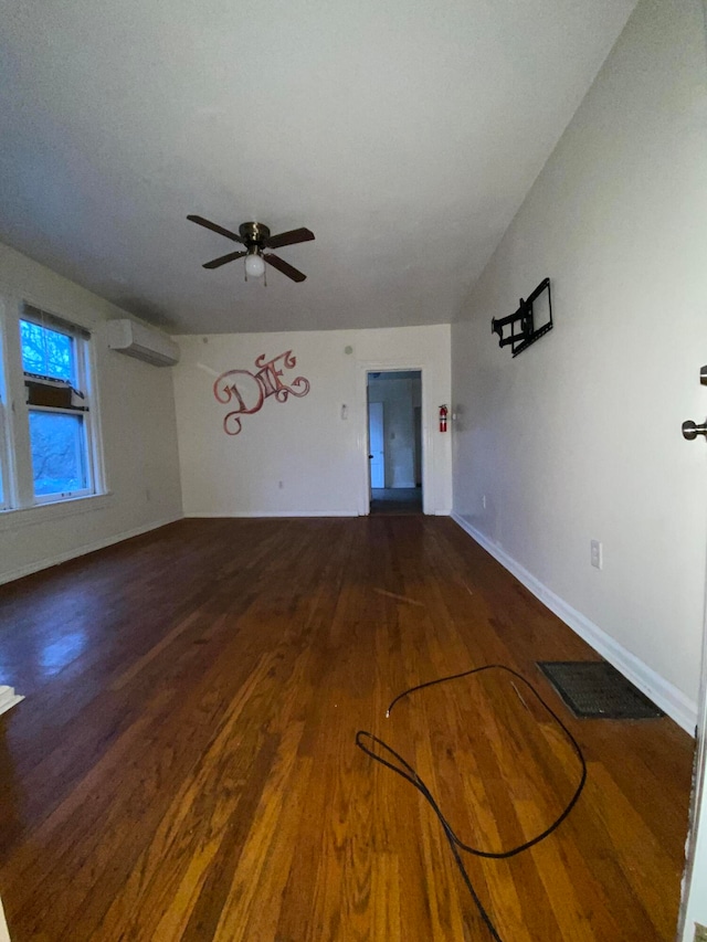 unfurnished living room featuring ceiling fan, dark hardwood / wood-style flooring, and a wall mounted air conditioner