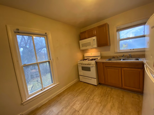 kitchen with a wealth of natural light, sink, and white appliances