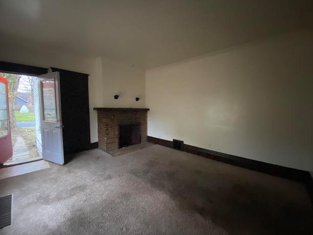 unfurnished living room with light colored carpet and a fireplace