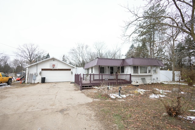 view of front facade featuring a wooden deck, an outbuilding, and a garage