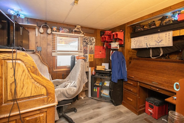 office with wooden walls and light hardwood / wood-style flooring