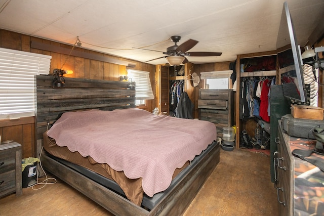 bedroom featuring a closet, wooden walls, and ceiling fan