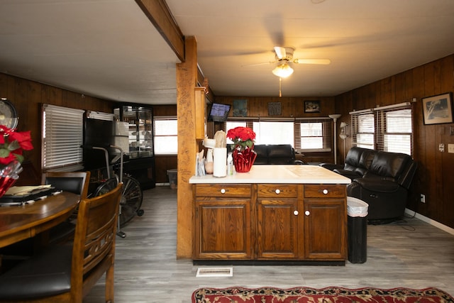 kitchen featuring wood walls, light hardwood / wood-style flooring, and ceiling fan