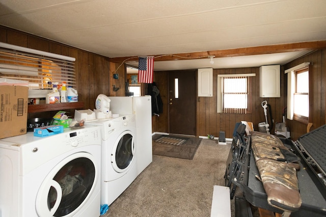 washroom featuring washing machine and dryer, wooden walls, and light carpet