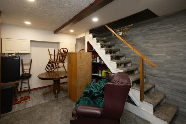 basement featuring dark colored carpet and a textured ceiling