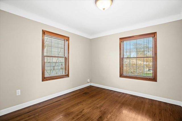 spare room with dark hardwood / wood-style flooring and plenty of natural light