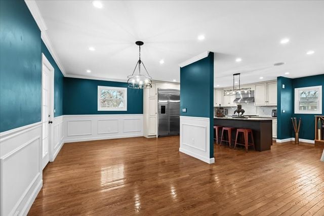 kitchen with white cabinetry, built in refrigerator, a kitchen island, and pendant lighting