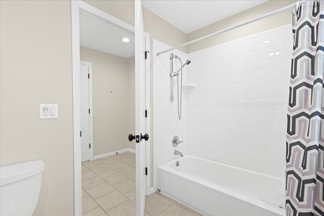 bathroom with toilet, tile patterned flooring, and shower / tub combo with curtain