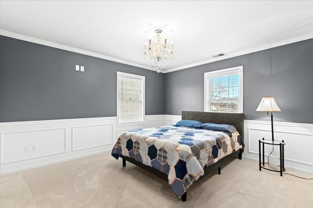 1807 Samoset Rd, Royal Oak, MI 48073 - carpeted bedroom featuring a decorative wall, a chandelier, a wainscoted wall, visible vents, and ornamental molding