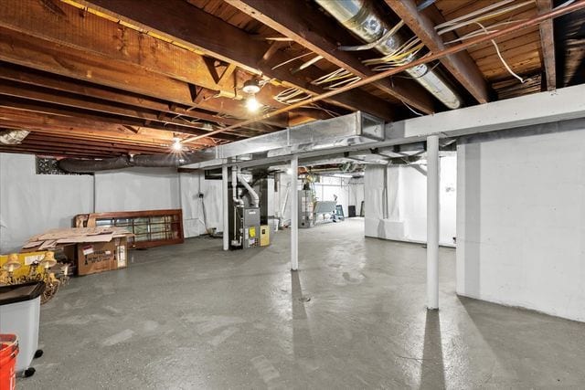 basement featuring gas water heater and heating unit